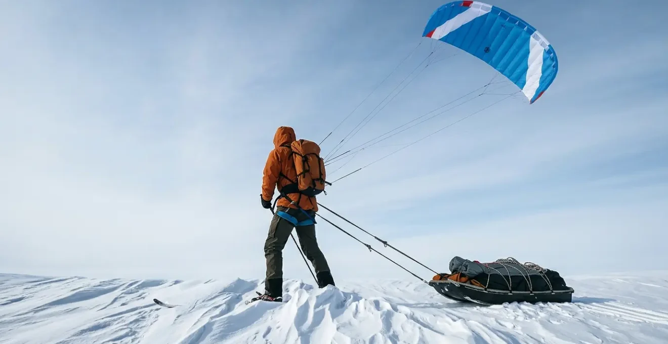 Explorateur polaire tracté par une aile à caissons dans un paysage arctique immaculé