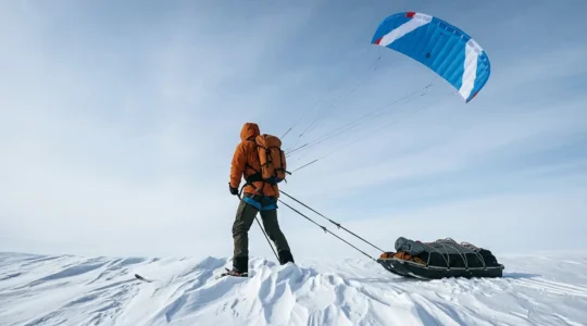 Explorateur polaire tracté par une aile à caissons dans un paysage arctique immaculé