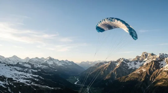 Aile de traction à caissons déployée dans un paysage de montagne, illustrant la légèreté et la polyvalence pour le voyage