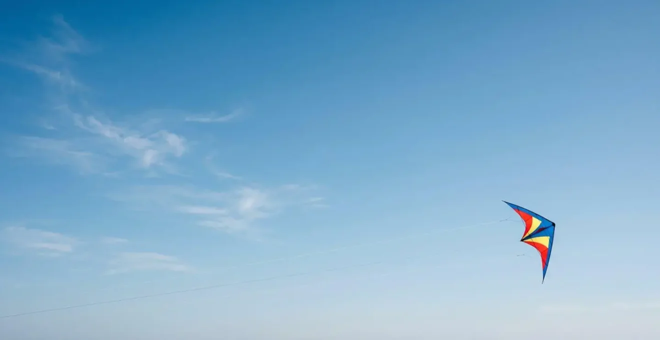Cerf-volant acrobatique traçant une trajectoire géométrique précise dans un ciel dégagé