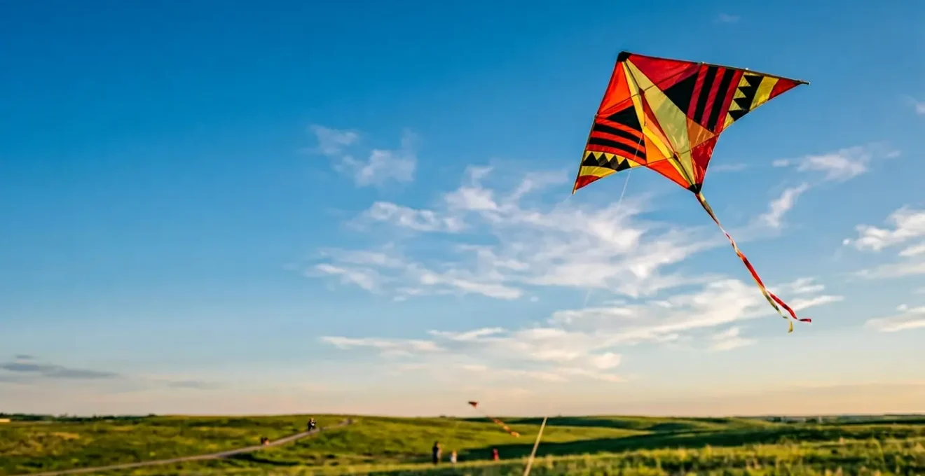 Cerf-volant artisanal aux couleurs vives flottant dans le ciel bleu, fabriqué avec des matériaux créatifs