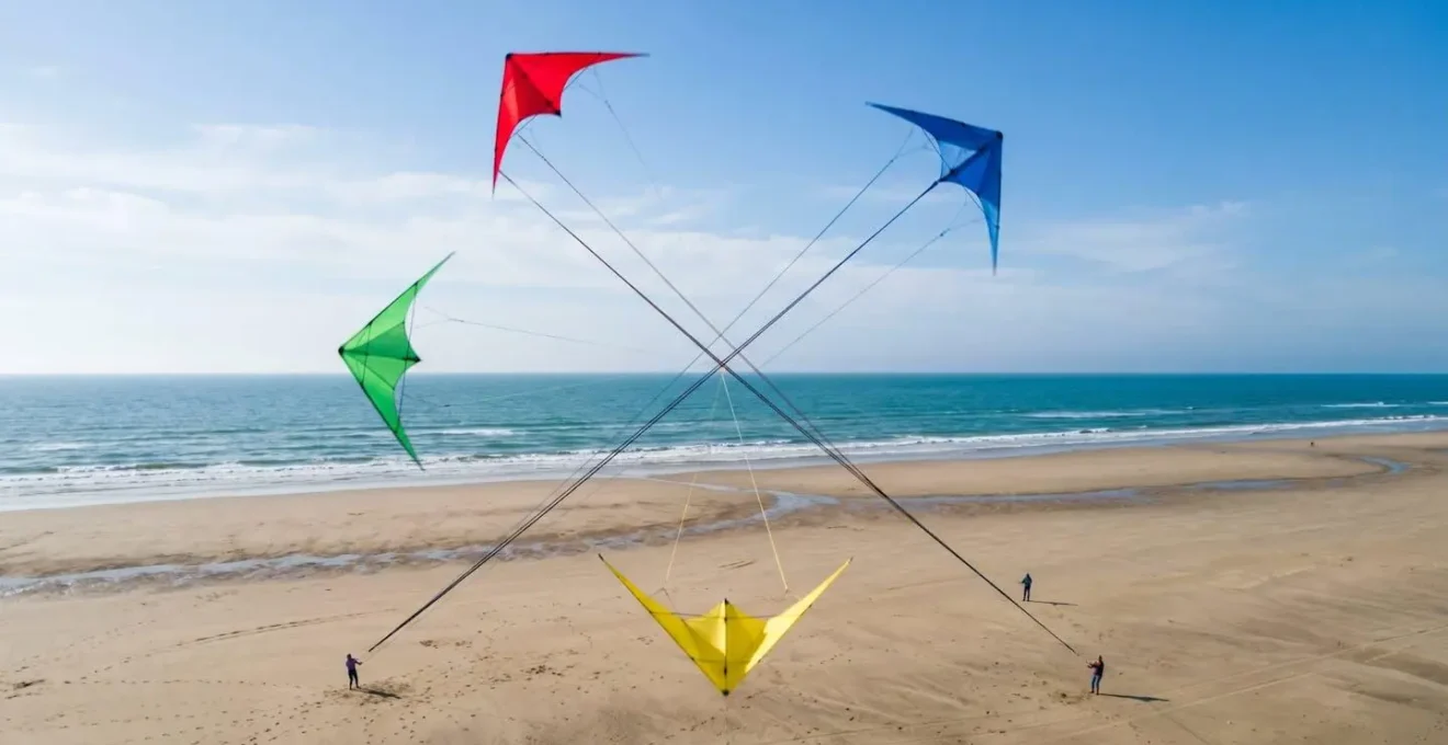 Vue aérienne abstraite montrant des trajectoires entrecroisées de cerfs-volants en formation, lignes tendues formant une géométrie précise