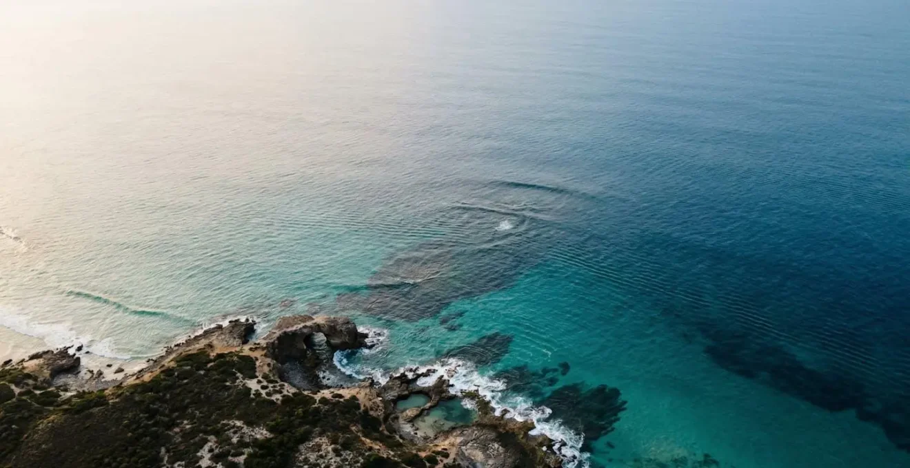 Vue aérienne d'un plan d'eau marin montrant les variations de couleur révélant courants et hauts-fonds pour la navigation en kitesurf