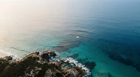 Vue aérienne d'un plan d'eau marin montrant les variations de couleur révélant courants et hauts-fonds pour la navigation en kitesurf