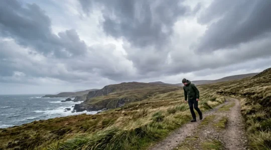 Personne marchant face au vent dans un paysage naturel ouvert, posture engagée et dynamique