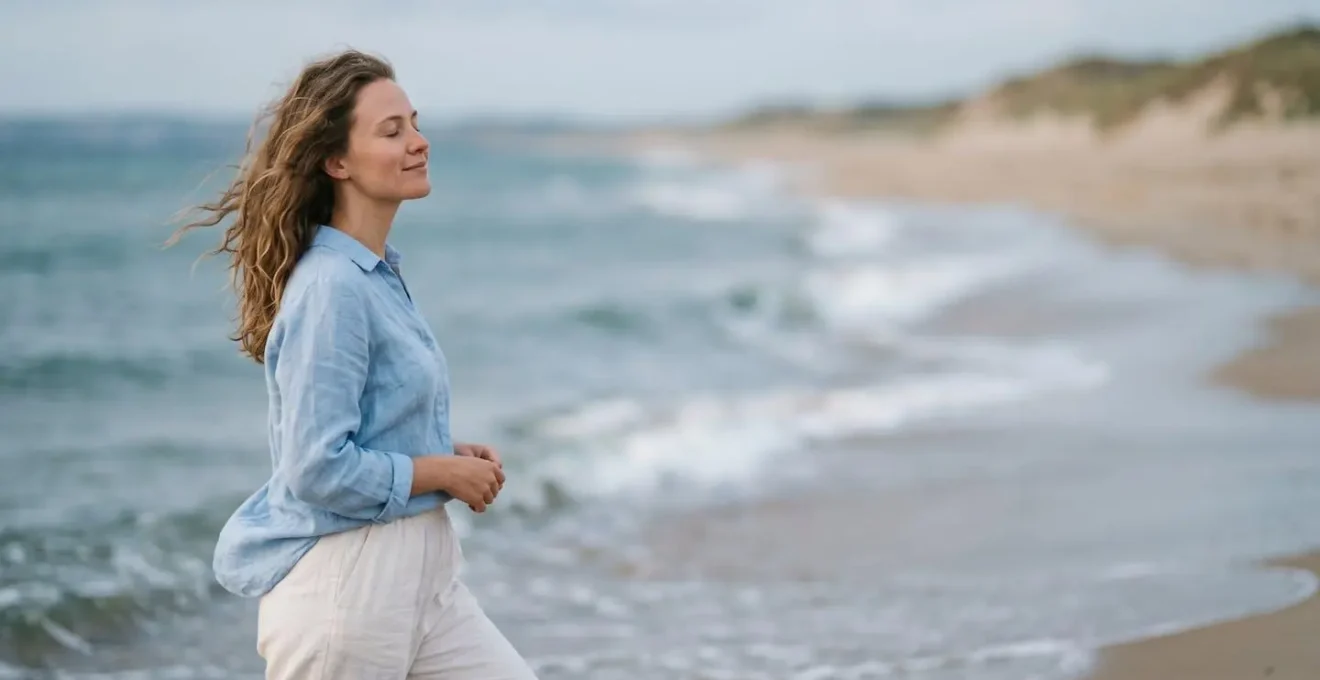Personne respirant profondément face au vent marin vivifiant au bord de mer