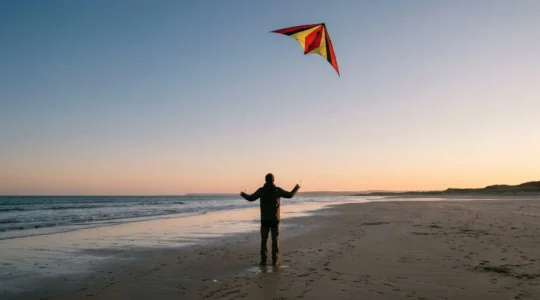 Pilote de cerf-volant acrobatique réalisant des figures géométriques précises dans le ciel avec un delta deux lignes