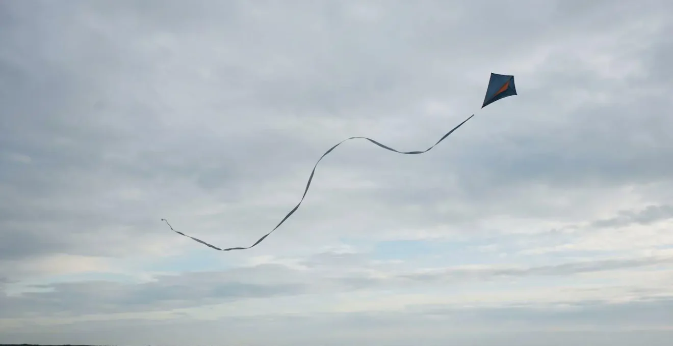Trajectoire asymétrique et imparfaite d'un cerf-volant dans le ciel, incarnant la philosophie wabi-sabi de la beauté éphémère