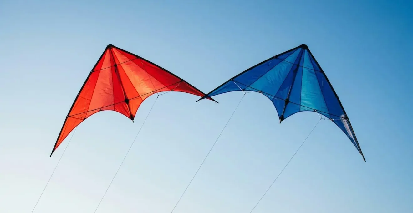 Deux cerfs-volants acrobatiques volant en formation serrée dans le ciel avec leurs lignes parallèles