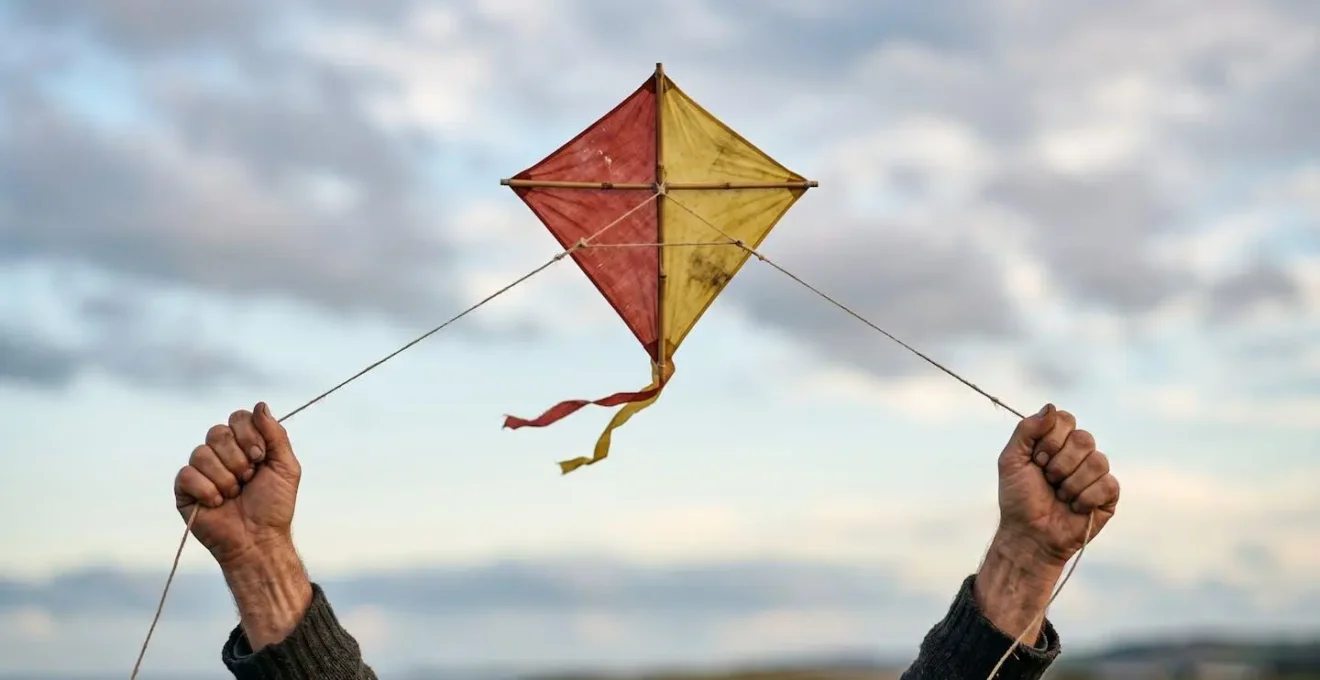 Cerf-volant maintenu en vol stationnaire parfait, symbolisant l'équilibre entre les forces invisibles et la maîtrise humaine